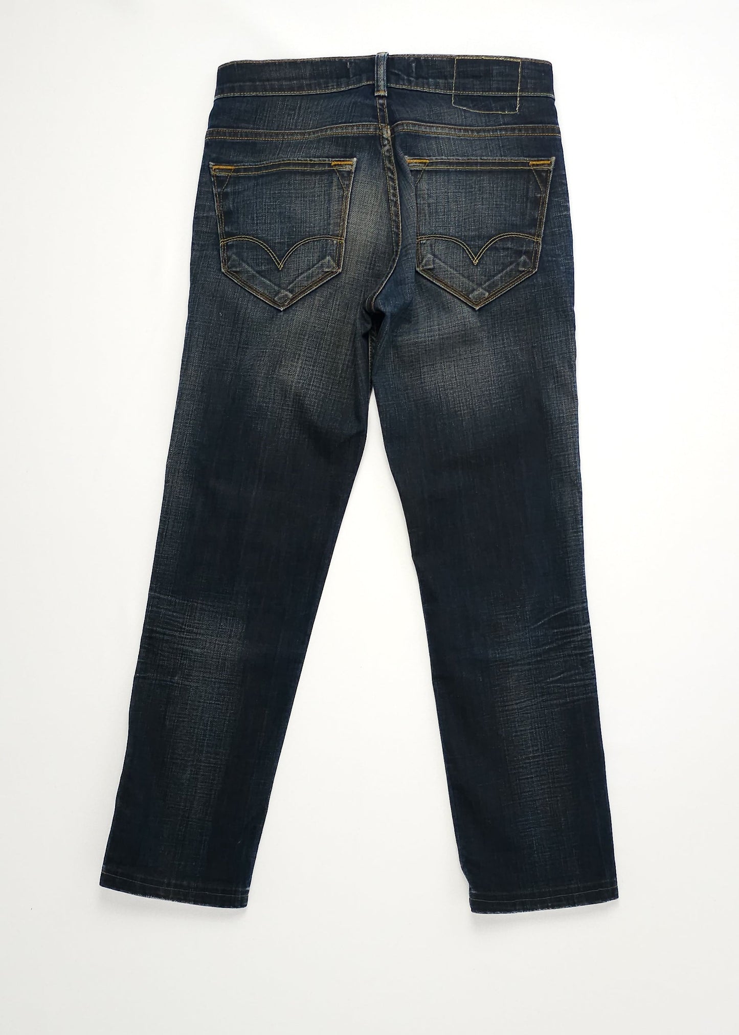 Dark blue denim jeans with a slight faded effect, featuring two back pockets with decorative stitching, displayed flat on a white surface.