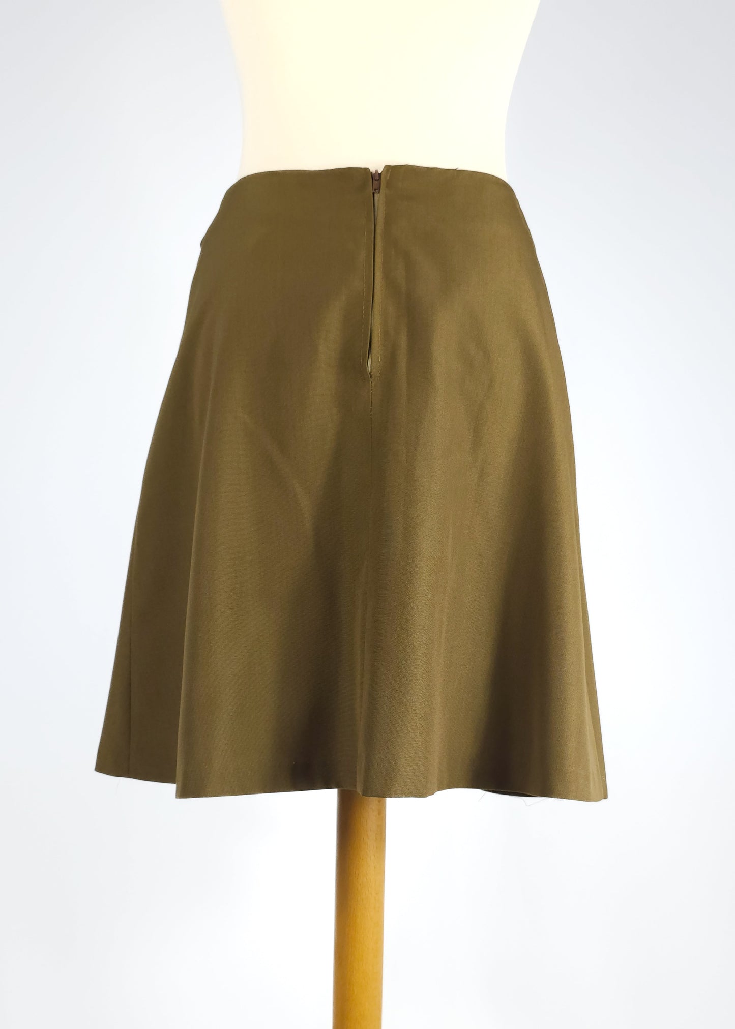 Olive green A-line skirt with a back zipper, displayed on a mannequin against a plain background.