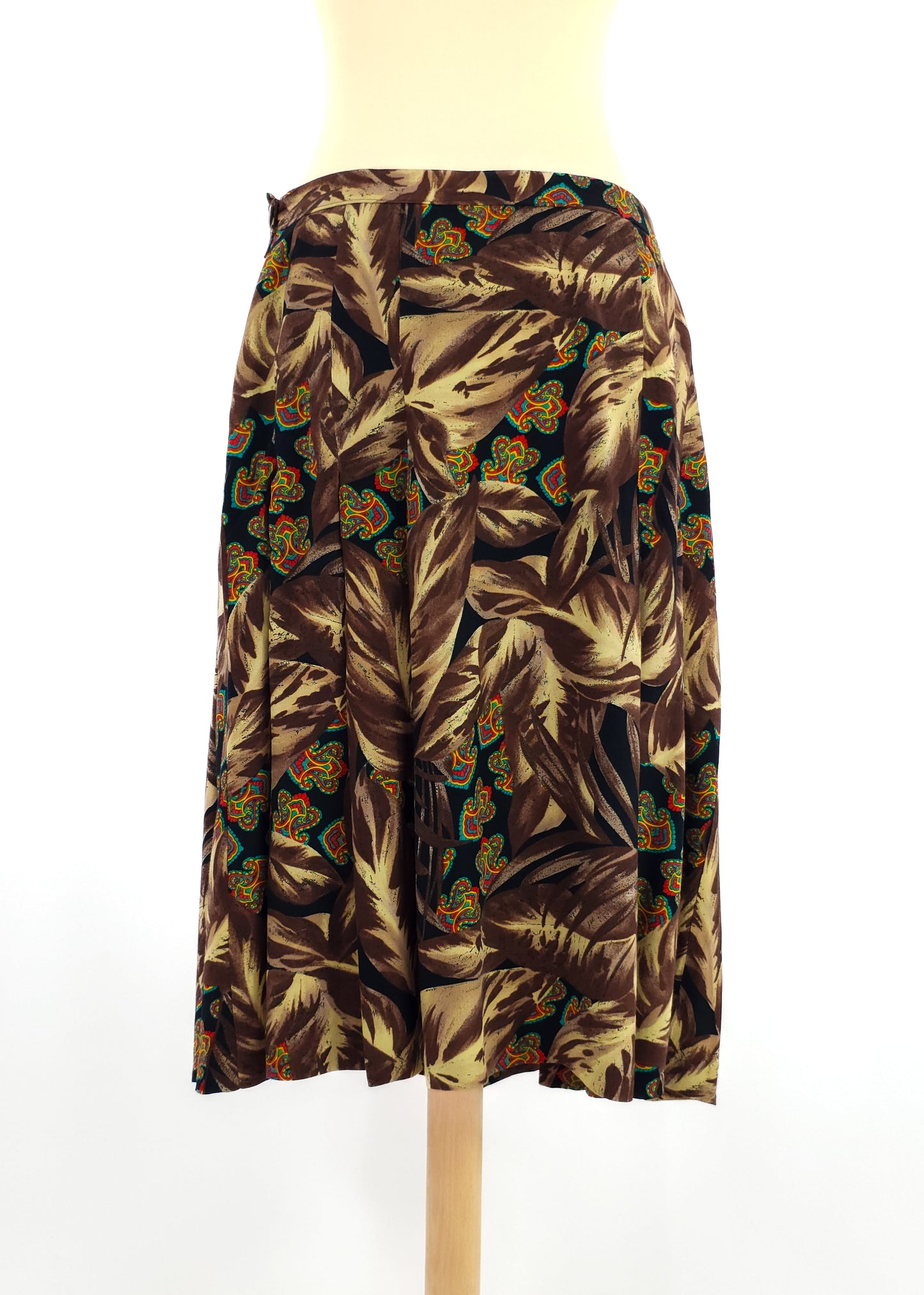A vintage brown midi skirt with a wrap design featuring a bold feather and geometric pattern in earthy tones and hints of orange and green.