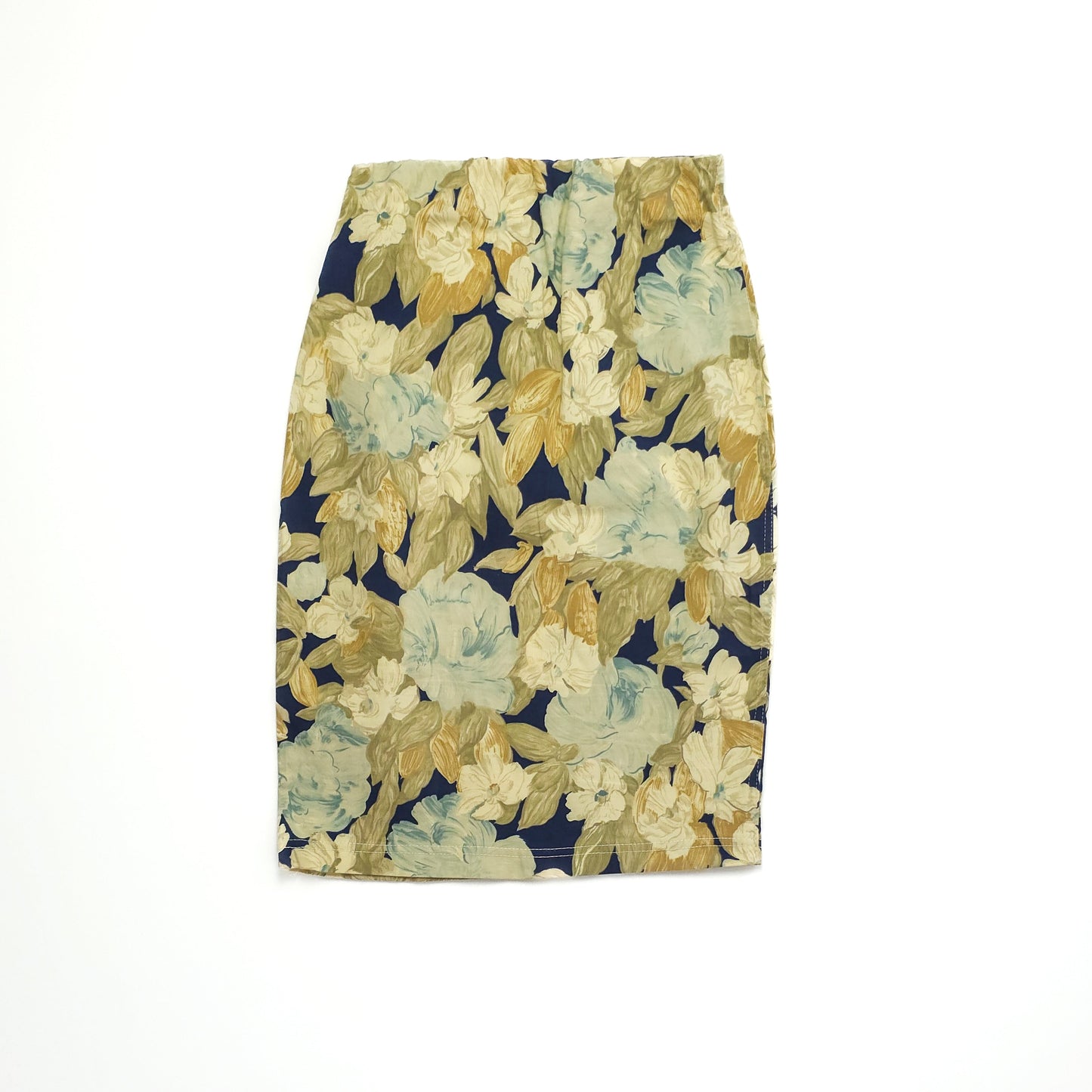 A floral pencil skirt with a navy blue background, featuring large beige and light green flowers in a vintage style, displayed against a white backdrop.