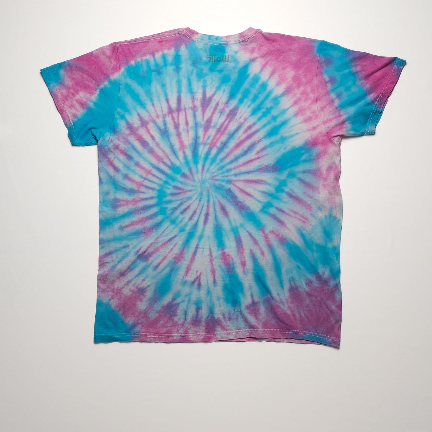 A tie-dye t-shirt with a vibrant spiral pattern in blue and pink colors. The shirt is laid flat with short sleeves and a round neckline.