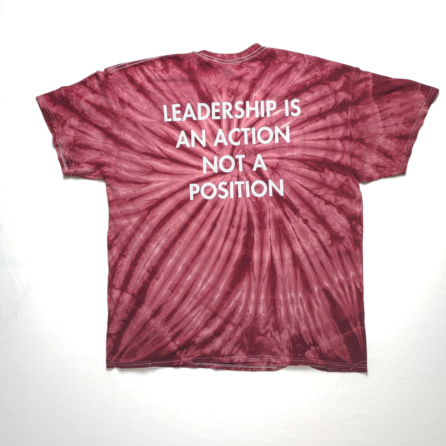 Maroon tie-dye t-shirt with white text on the back reading "Leadership is an action, not a position."