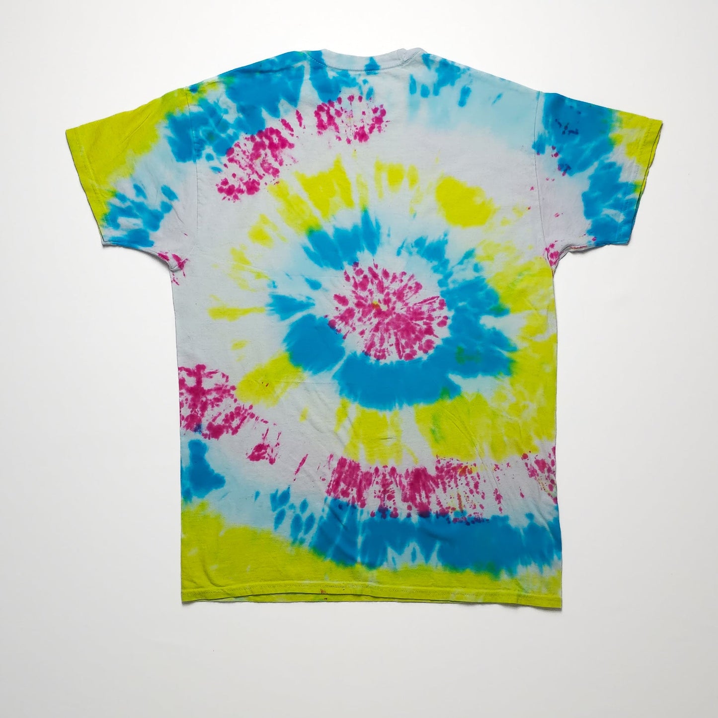 A colorful tie-dye t-shirt featuring vibrant spirals of blue, yellow, and pink on a white background, with short sleeves and a classic crew neckline.