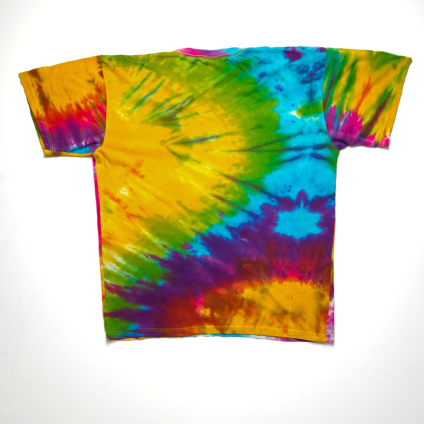 A colorful tie-dye t-shirt with a vibrant mix of yellow, blue, green, pink, and purple swirls creating a dynamic and eye-catching pattern.