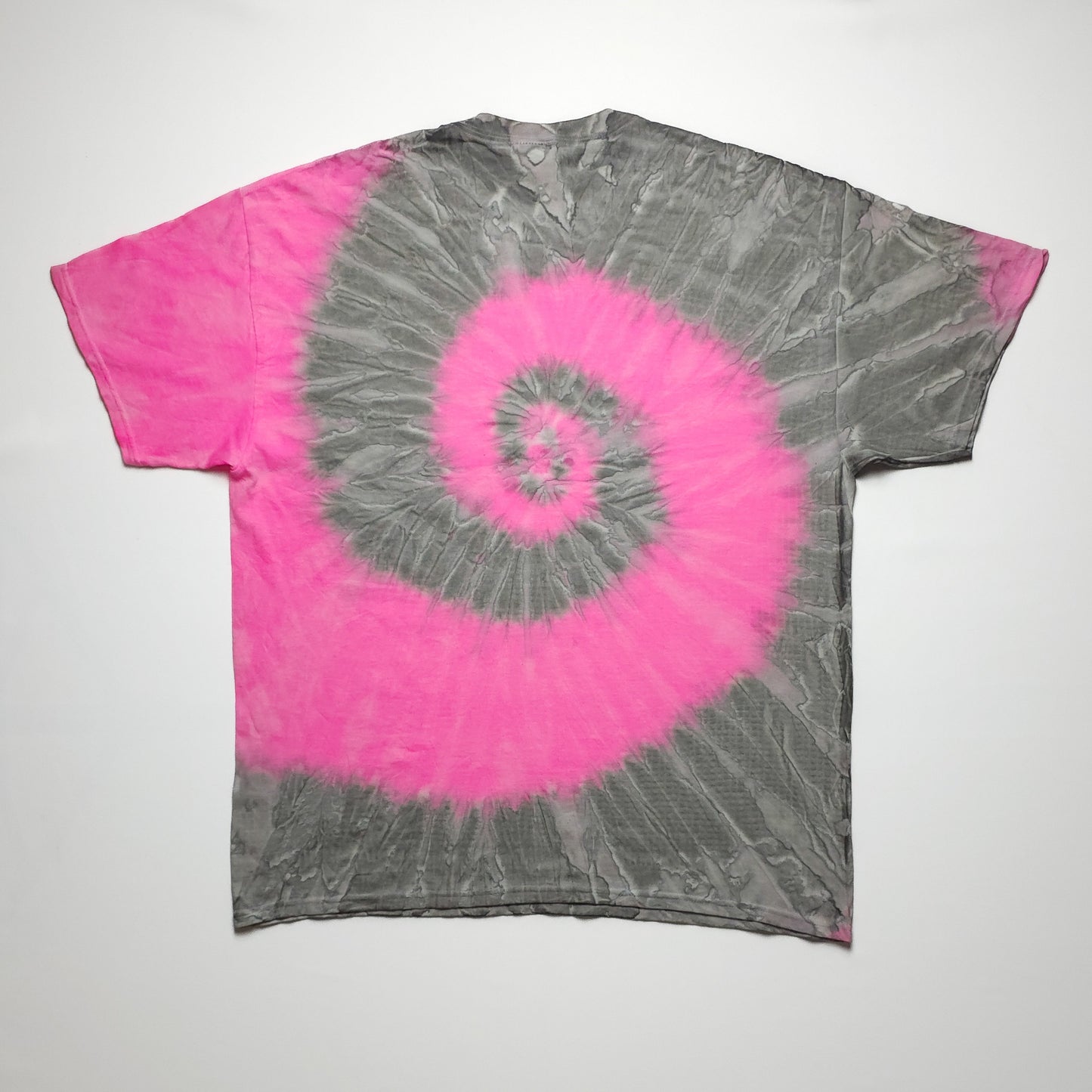 Gray and pink tie-dye t-shirt featuring a spiral pattern, with short sleeves. The spiral design starts from the center and expands outward.