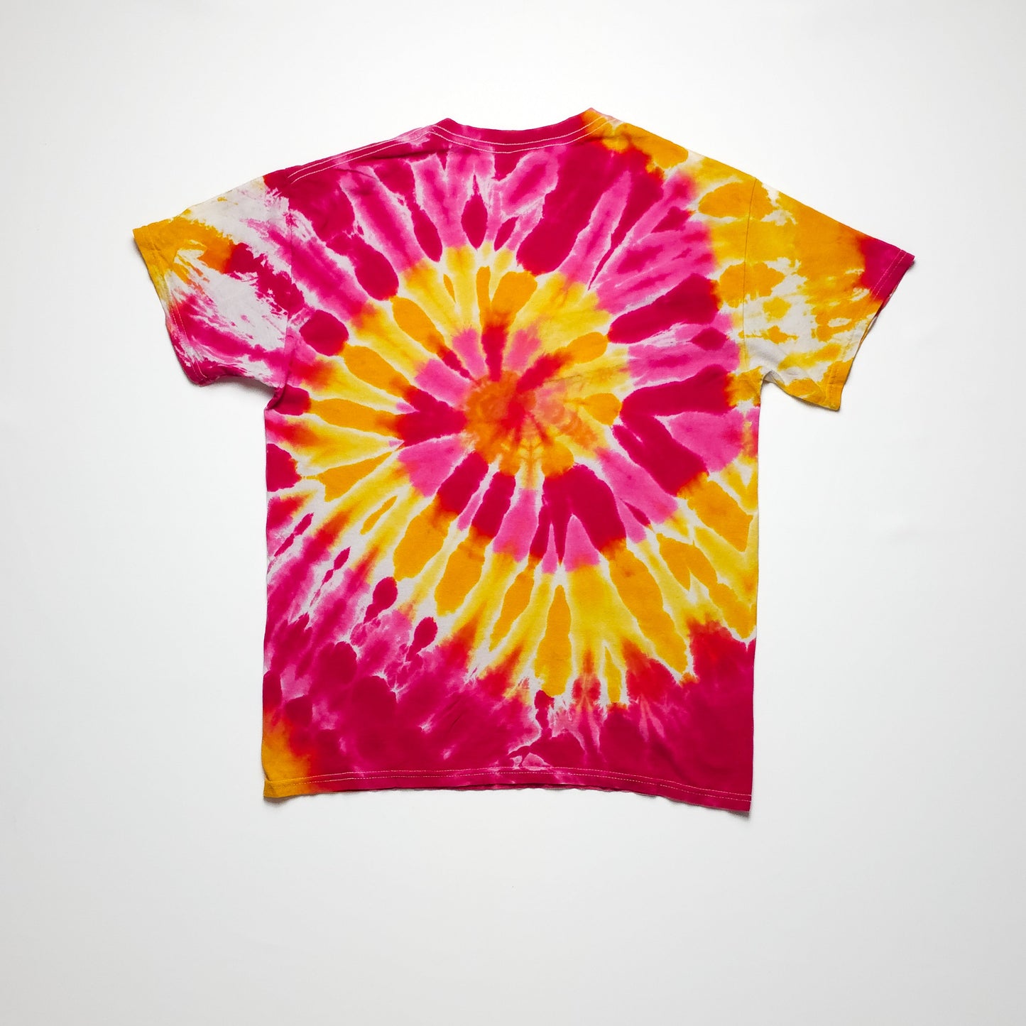 A vibrant tie-dye T-shirt with a spiral pattern in yellow, pink, and orange displayed against a plain white background.
