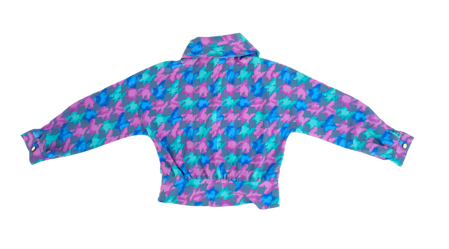 Colorful vintage jacket with a bold houndstooth pattern in pink, turquoise, and purple. Features long sleeves and a high collar, spread out on a white background.