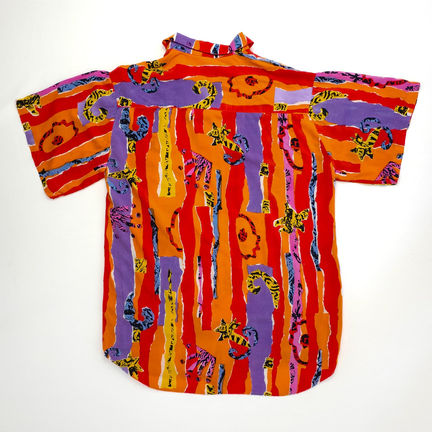 A vibrant, short-sleeve shirt featuring a colorful pattern of red, purple, and orange stripes with abstract animal designs, displayed against a plain background.
