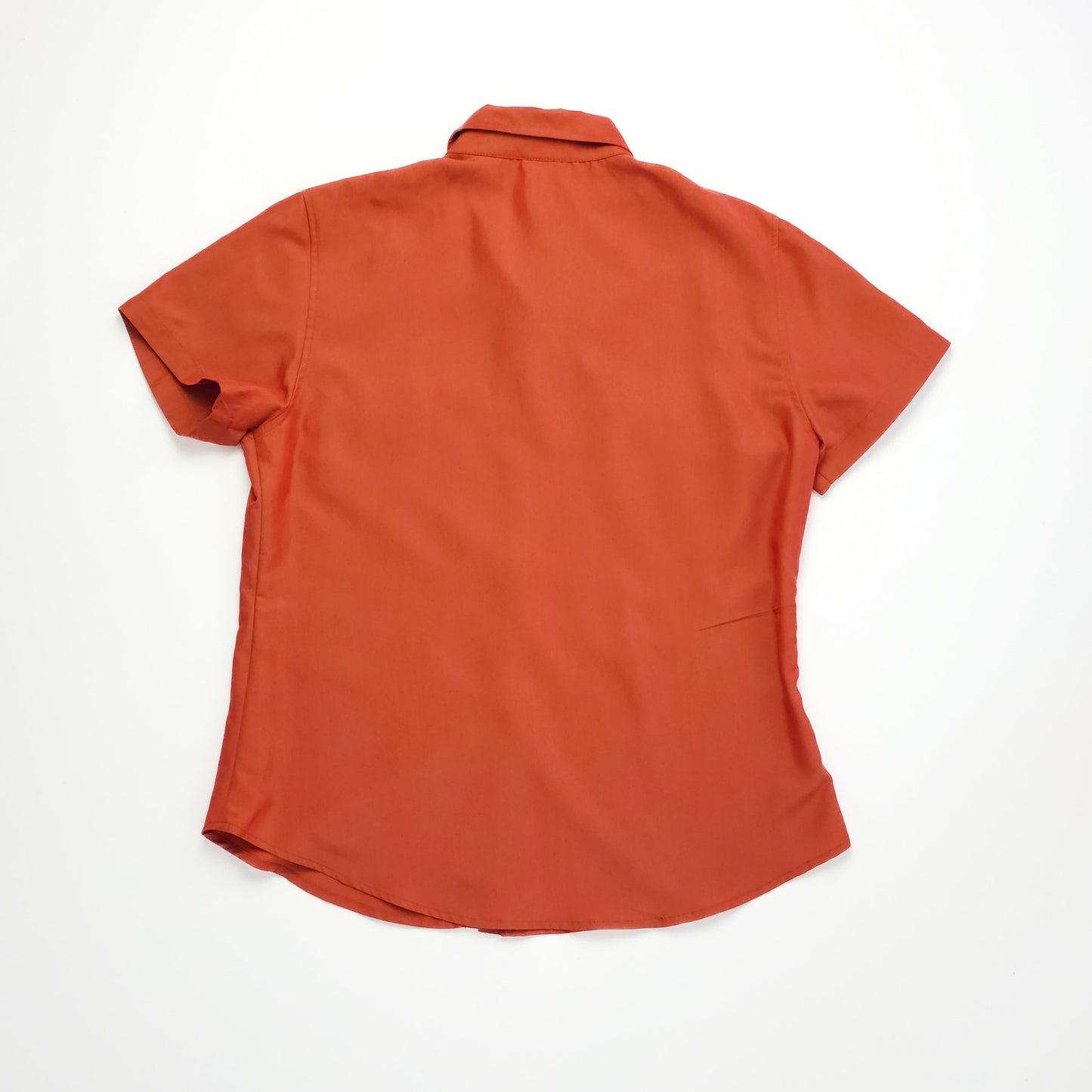 A short-sleeved, rust-colored button-up shirt with a collar, laid flat, showing the back view against a white background.