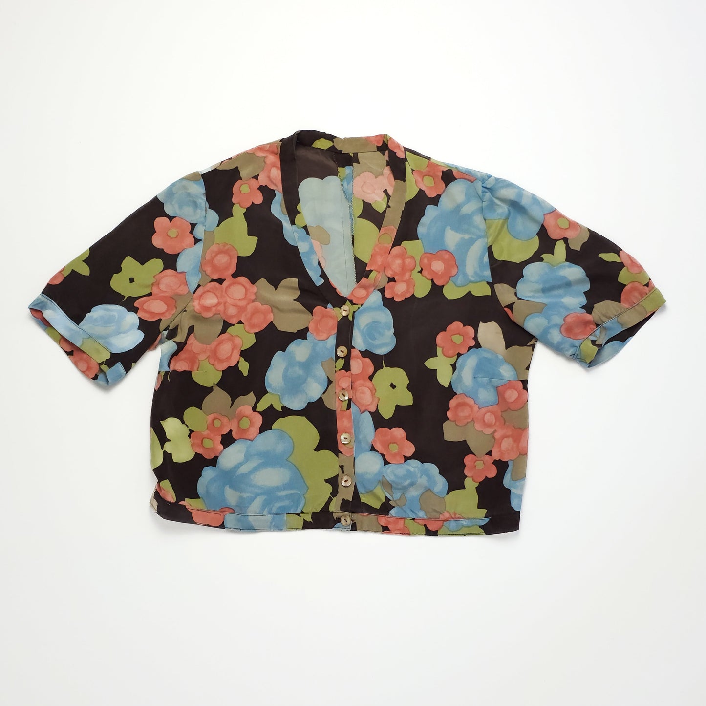 Floral blouse with a colorful pattern of pink, blue, and green flowers.