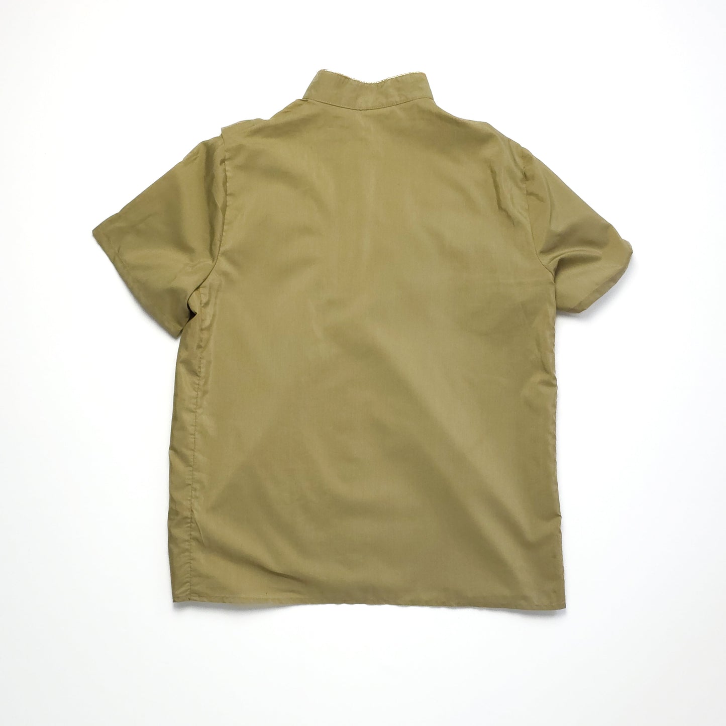 A beige short-sleeve button-up shirt shown from the back, with a straight hem and a simple collar, against a plain white background.