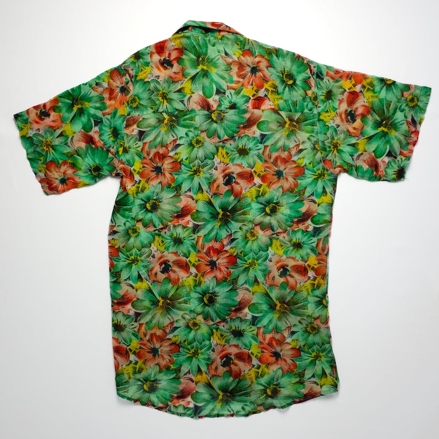 A vibrant, short-sleeved shirt with a green base and an all-over floral pattern featuring red, yellow, and green flowers, displayed on a plain background.