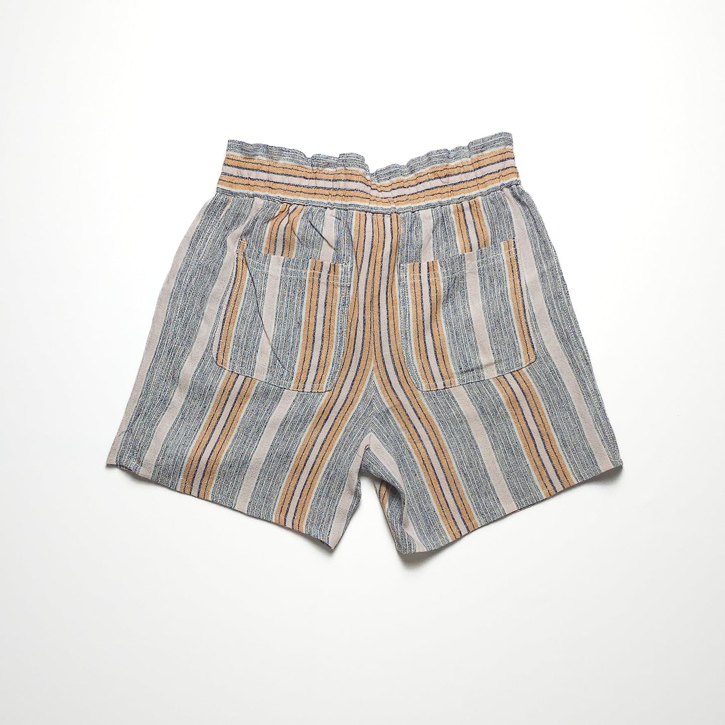 Striped shorts with an elastic waistband and two large front pockets. Shorts feature vertical stripes in blue, yellow, and white on a light background.