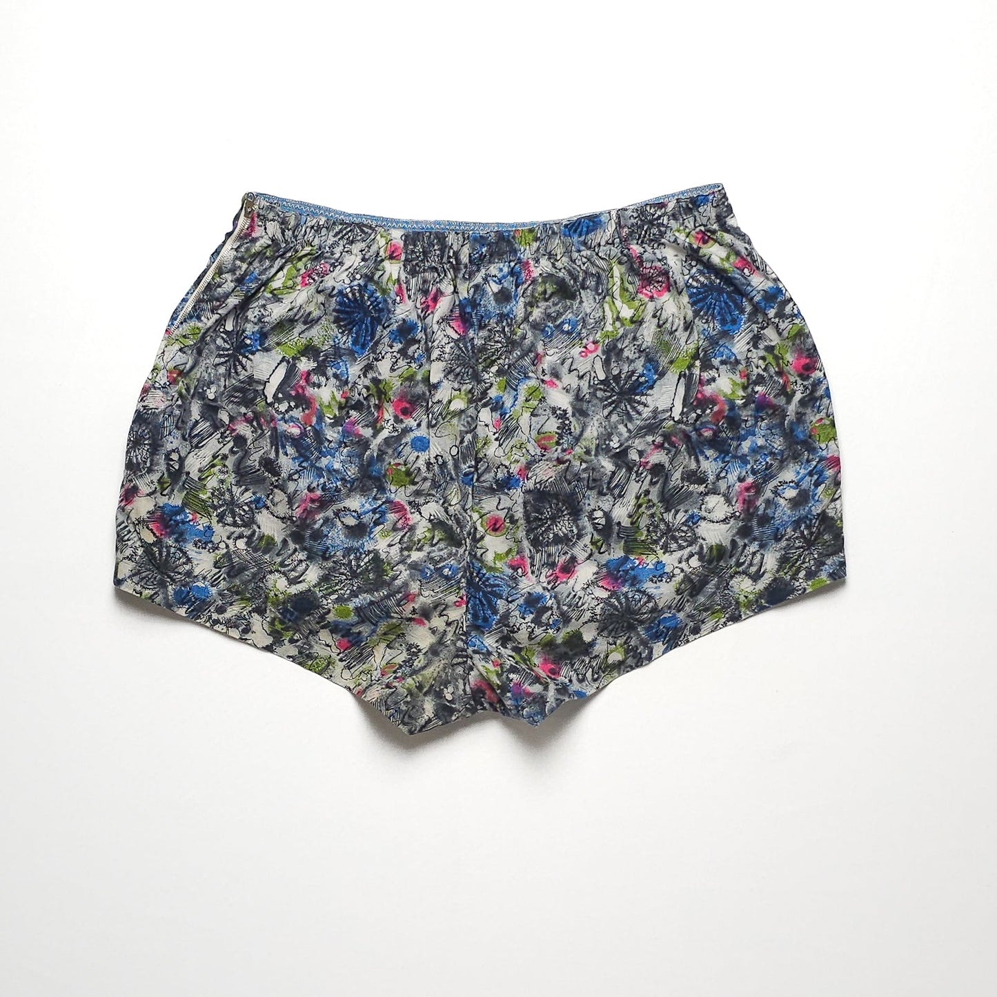 Floral-patterned women's shorts featuring a mix of blue, green, and pink colors, displayed on a white background.