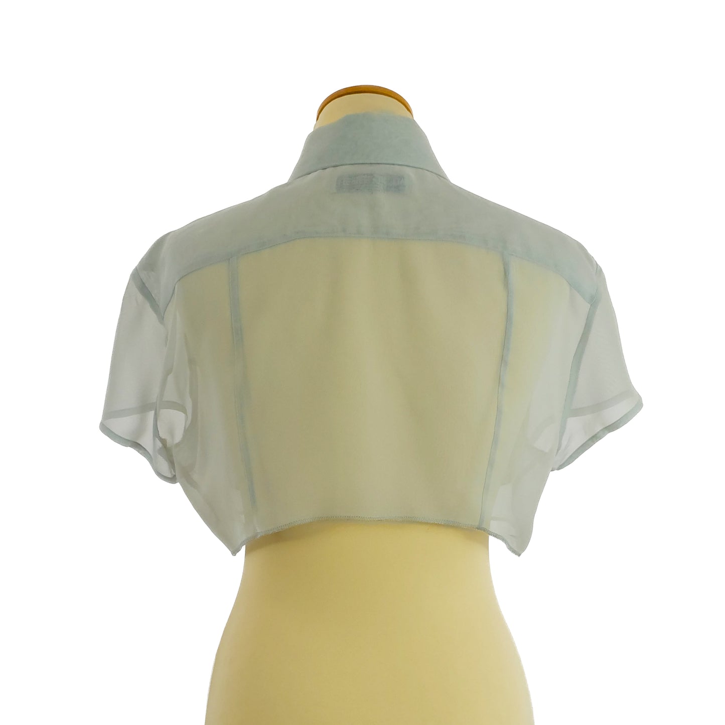 Sheer light blue cropped bolero jacket displayed on a mannequin, featuring short sleeves and a simple, open front design.
