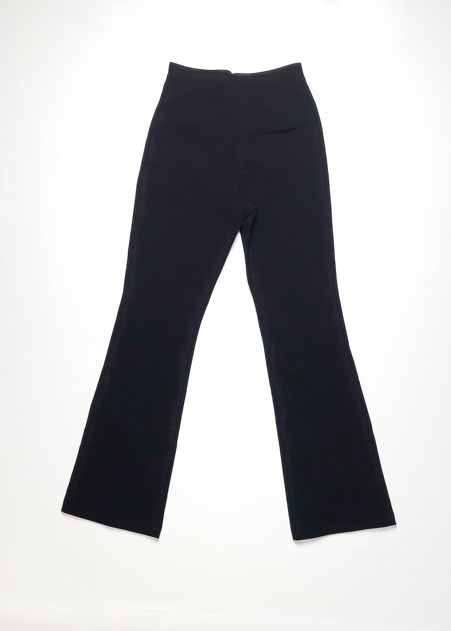 Black high-waisted flared pants on a white background. The pants have a sleek, minimalist design with a fitted waist and gently widening legs.
