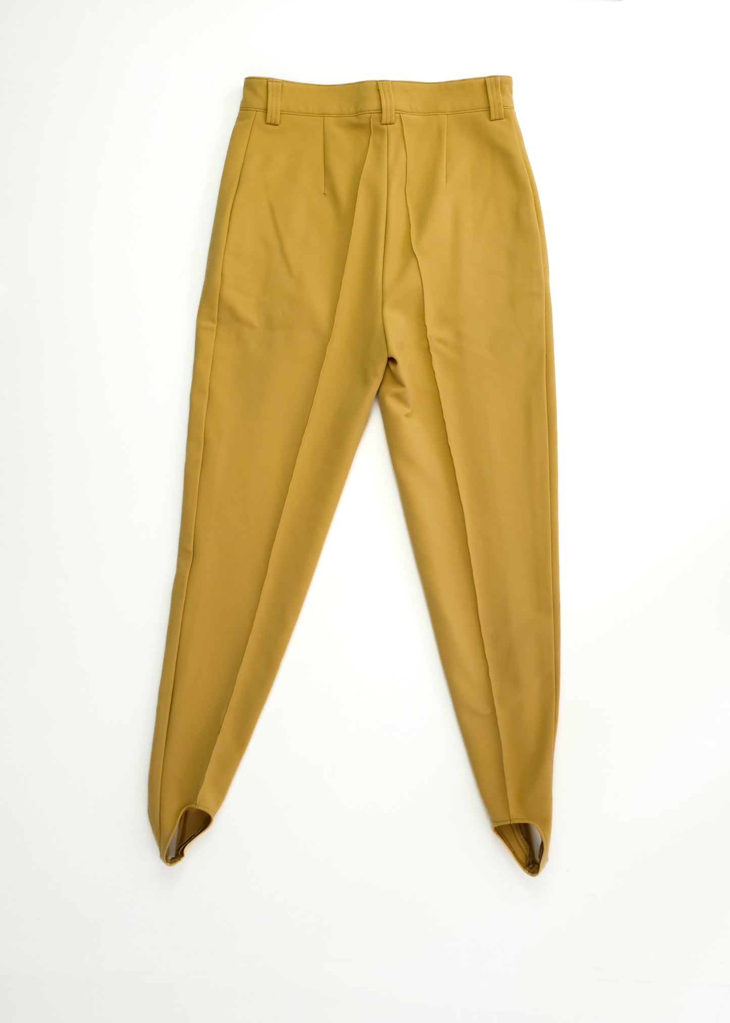 Pair of high-waisted, tan cigarette pants with a fitted waistband and tapered legs, featuring stirrups at the hem, laid flat on a white background.