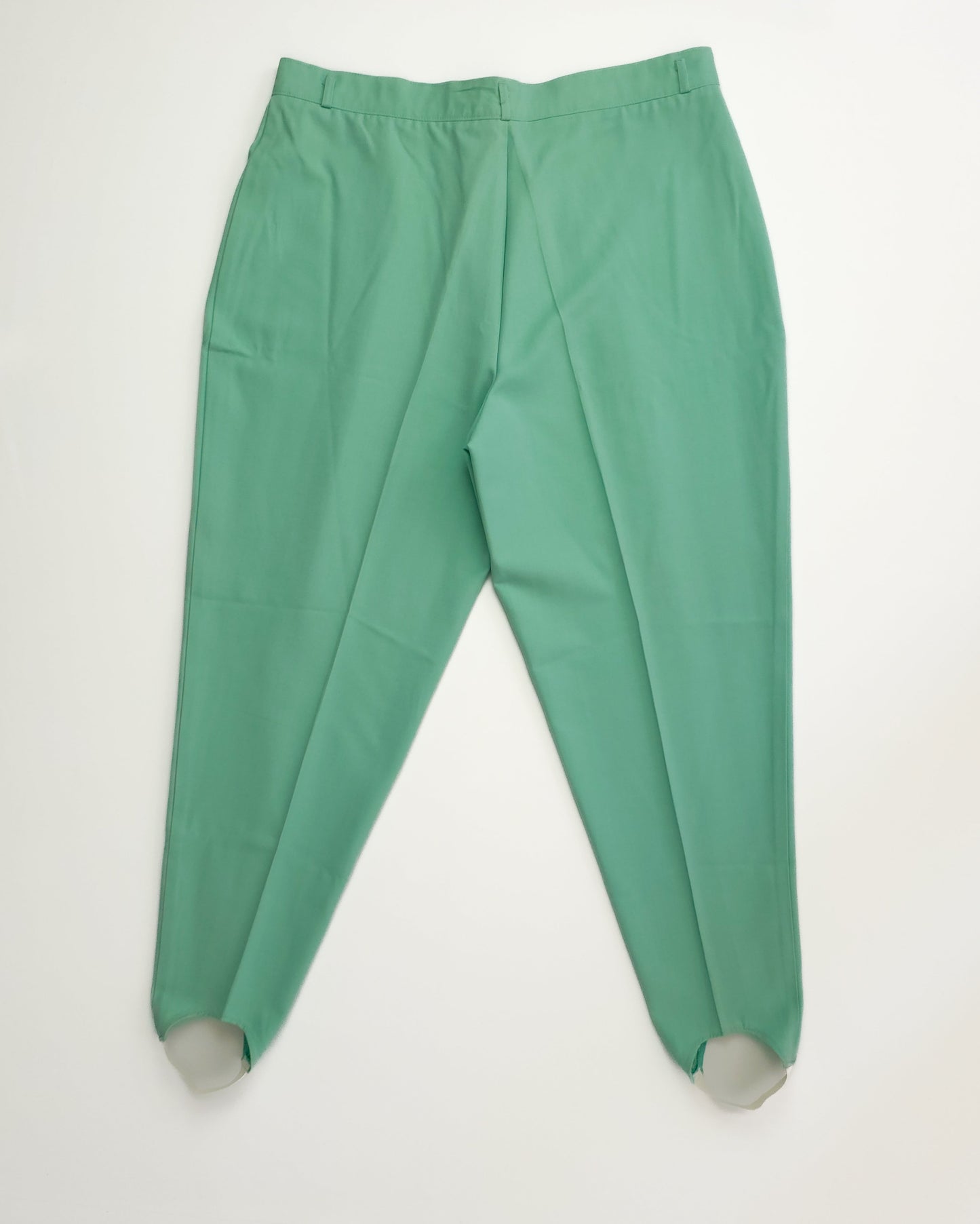 Green high-waisted pants with stirrup straps at the hem, laid flat on a white background.