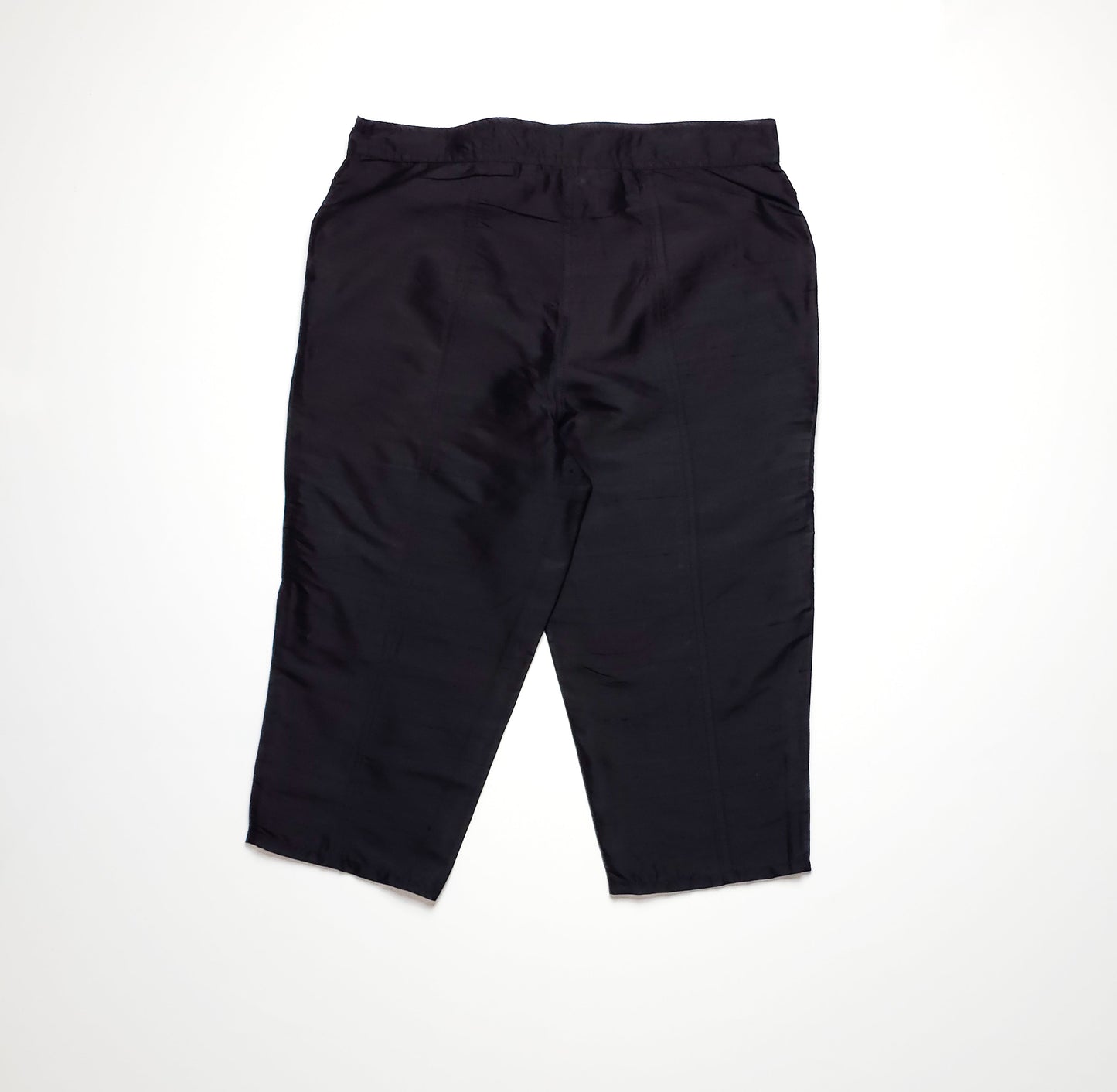 Black, tailored pants with a high waist and cropped, straight legs, laid flat on a white background.