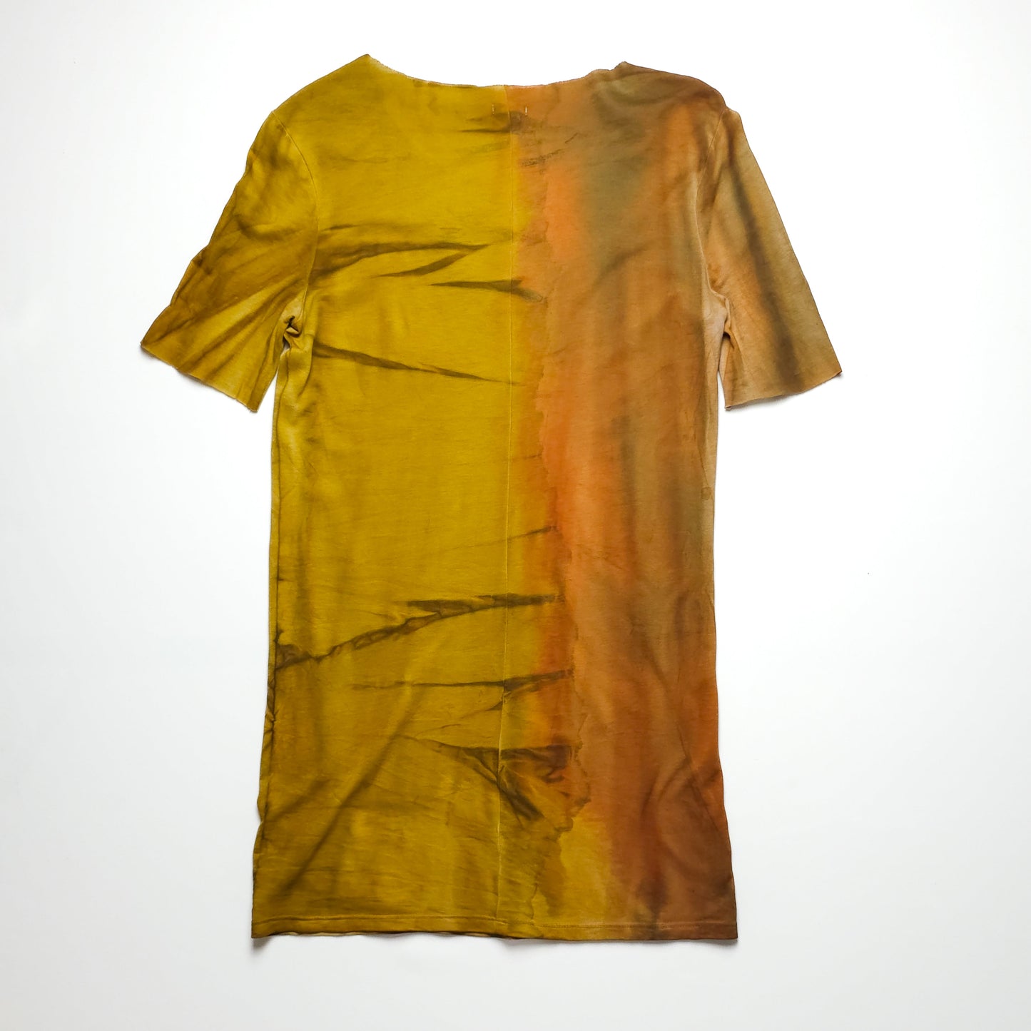 A tie-dye T-shirt in shades of yellow, brown, and orange with abstract patterns and a short sleeve design laid flat on a white background.