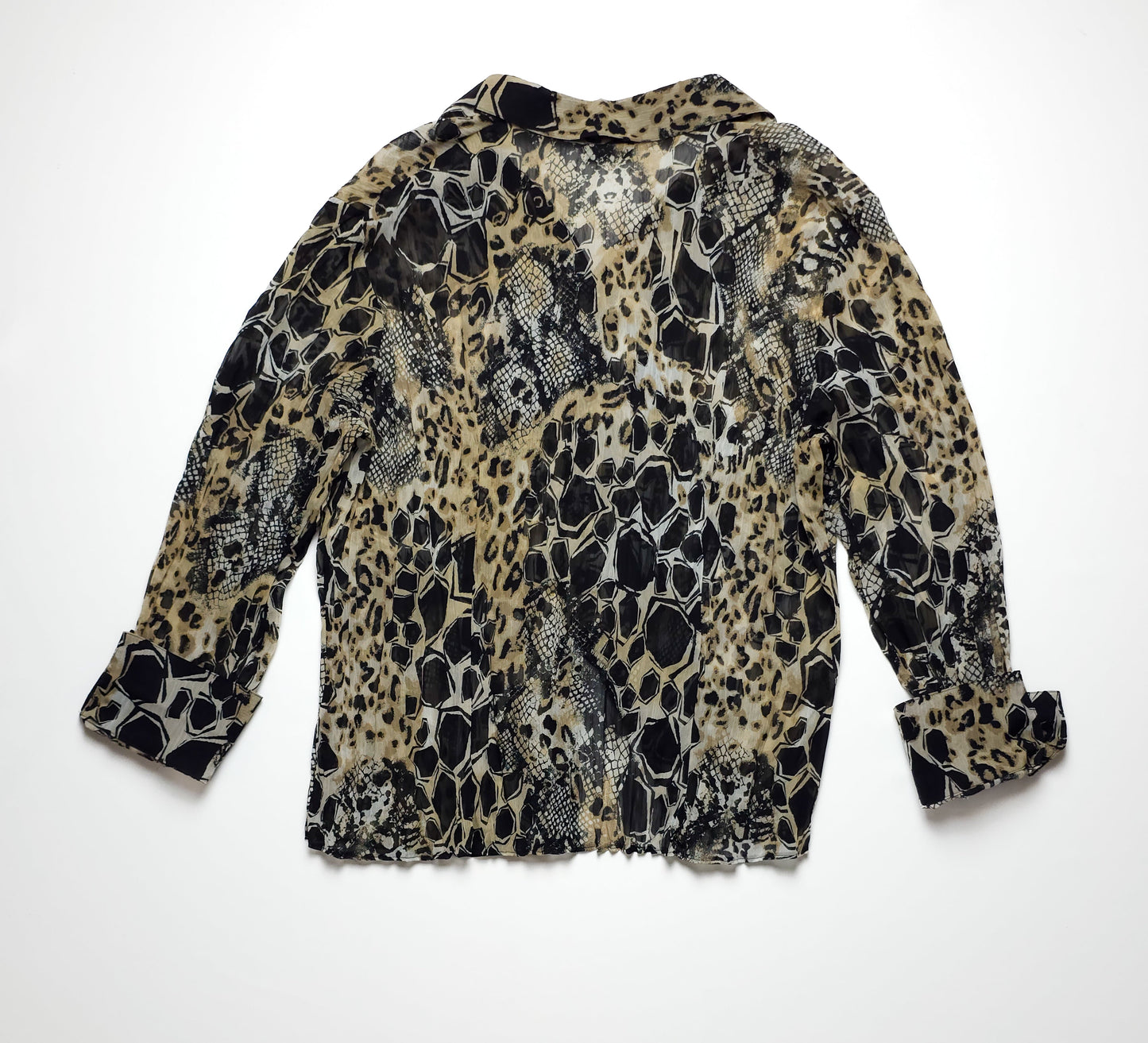 A long-sleeved, animal print blouse with a mix of leopard and snake patterns in black, brown, and white. The blouse has a slightly sheer fabric and a relaxed fit.