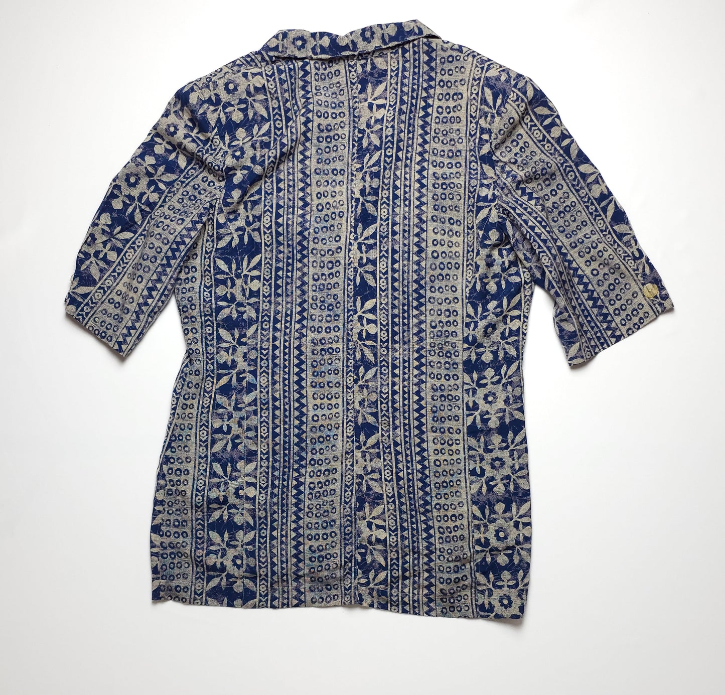 A blue and white floral patterned shirt with a vertical stripe design, featuring half sleeves and a collar, laid flat against a white background.