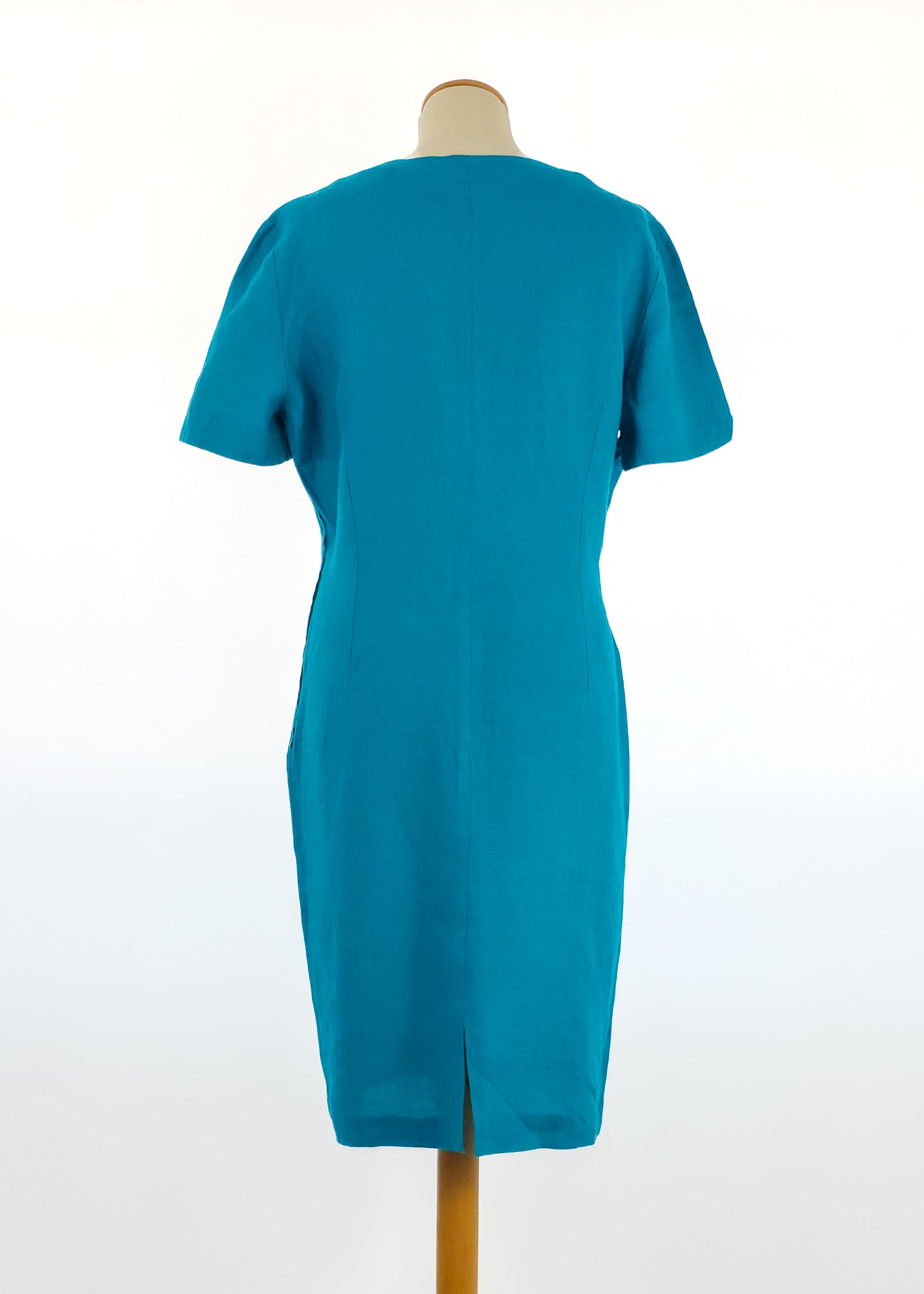 A teal, short-sleeved, knee-length dress displayed on a mannequin with a simple, clean back design and a centered back seam ending in a small slit.