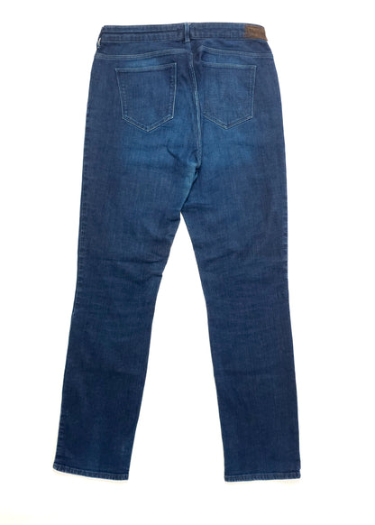 Back view of a pair of dark blue denim jeans featuring two back pockets and a brown leather patch on the waistband.