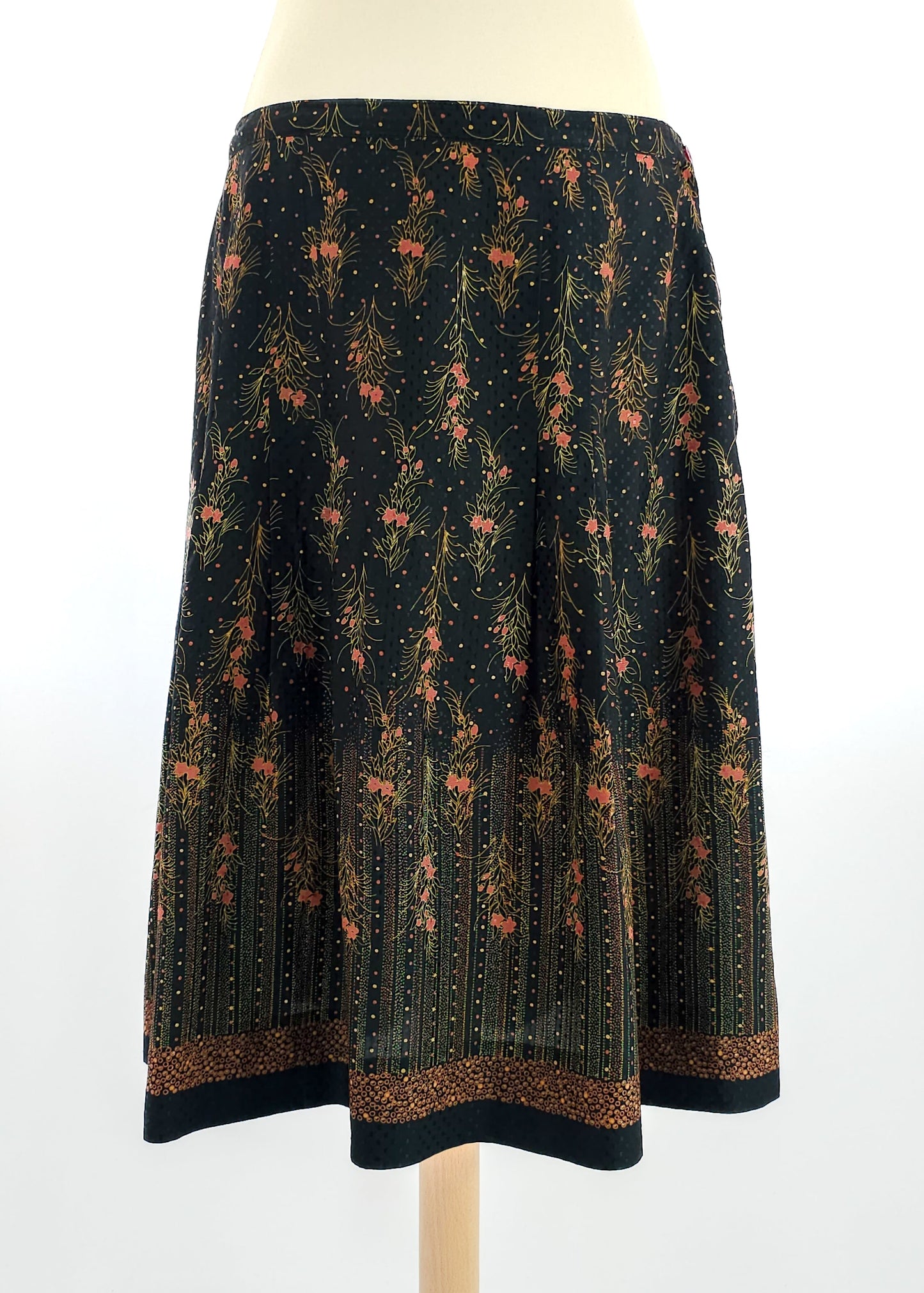A vintage floral midi skirt with a dark background and intricate floral patterns in warm tones.