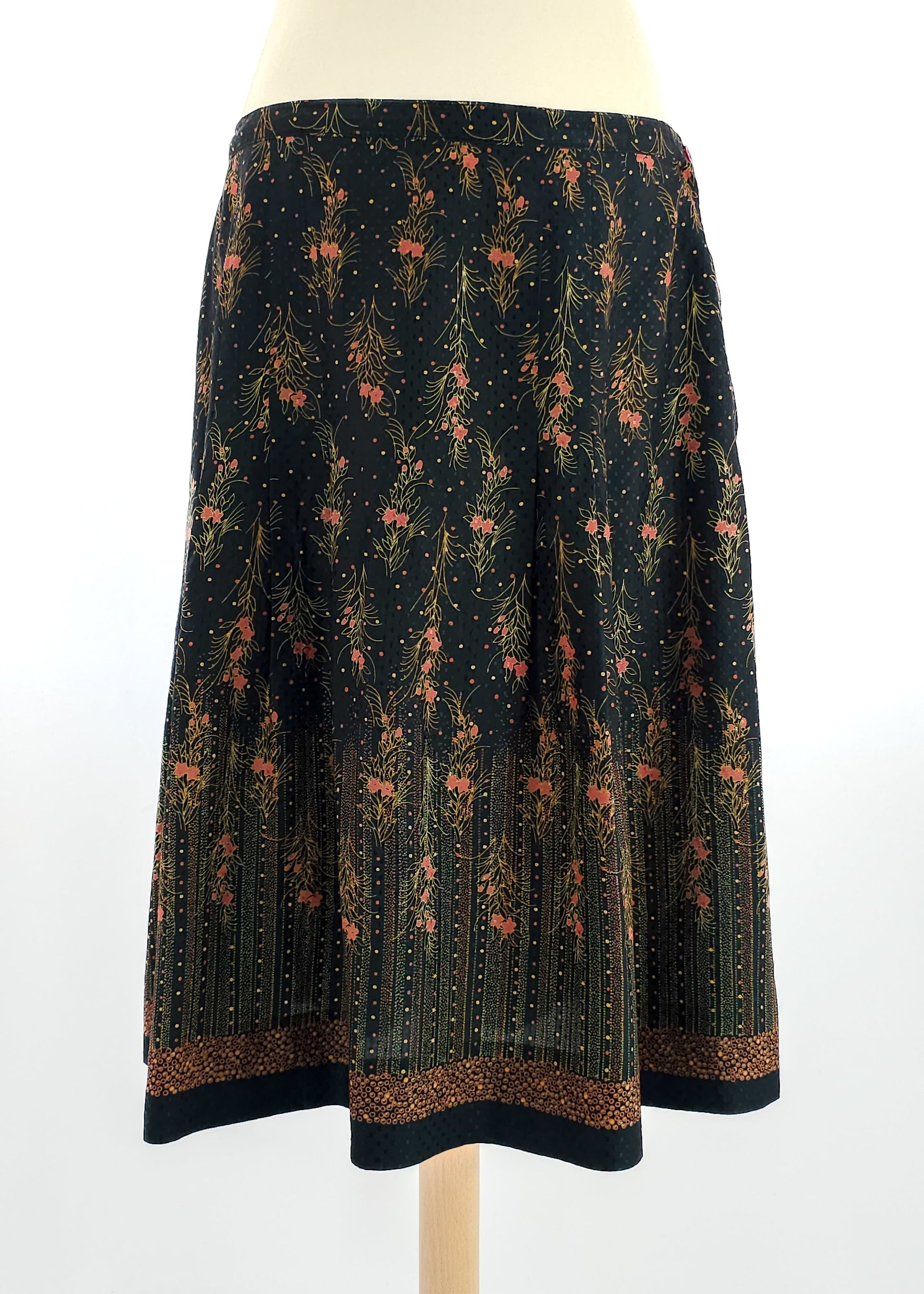 A vintage floral midi skirt with a dark background and intricate floral patterns in warm tones.