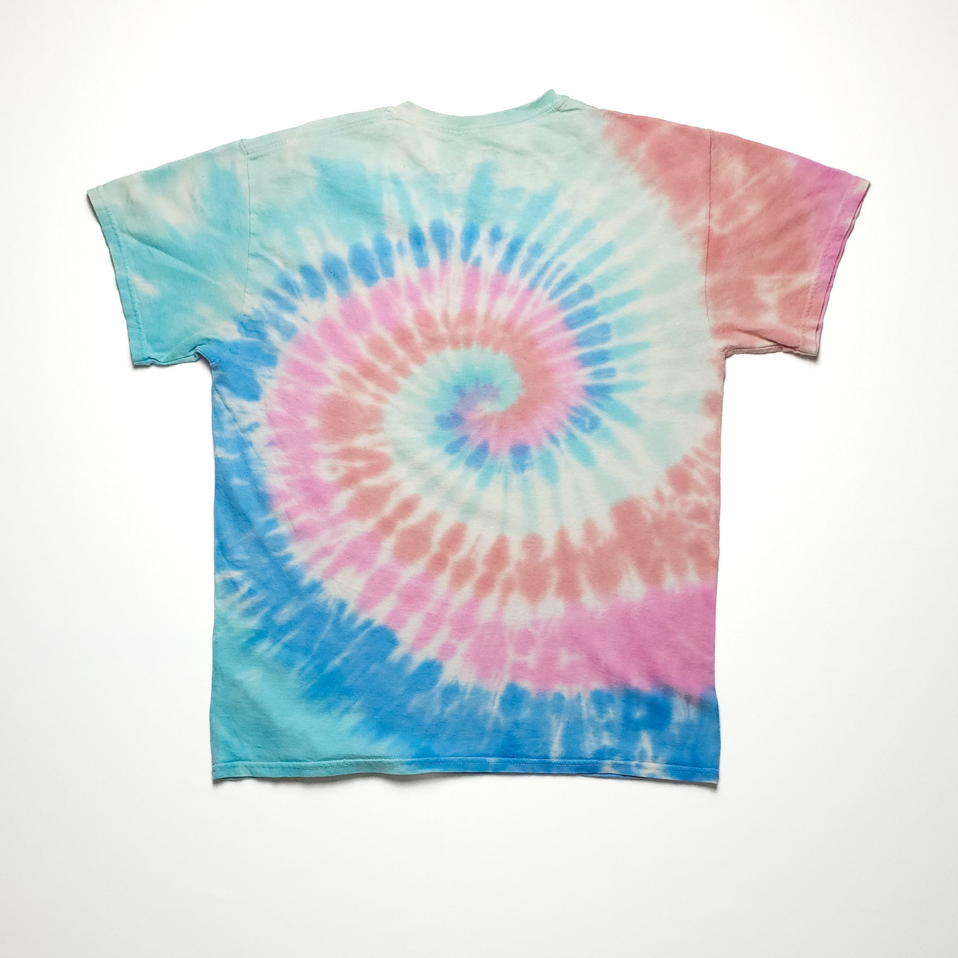 A tie-dye T-shirt featuring a spiral pattern in pastel colors of blue, pink, and purple, displayed on a plain white background. The shirt is short-sleeved.