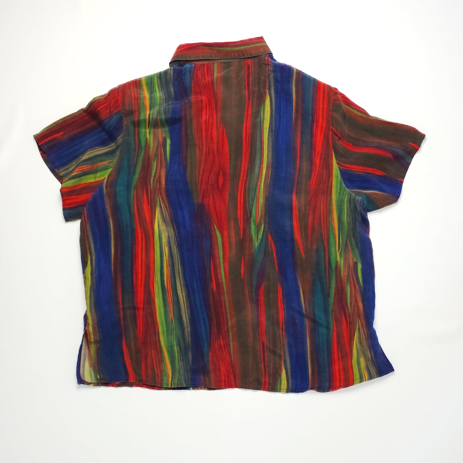 A short-sleeved, button-up shirt featuring a vibrant pattern of vertical, multicolored stripes in red, green, yellow, and blue on a dark background.