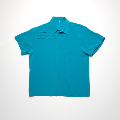 Teal short-sleeve blouse with a pointed collar and subtle pleated details on the front.