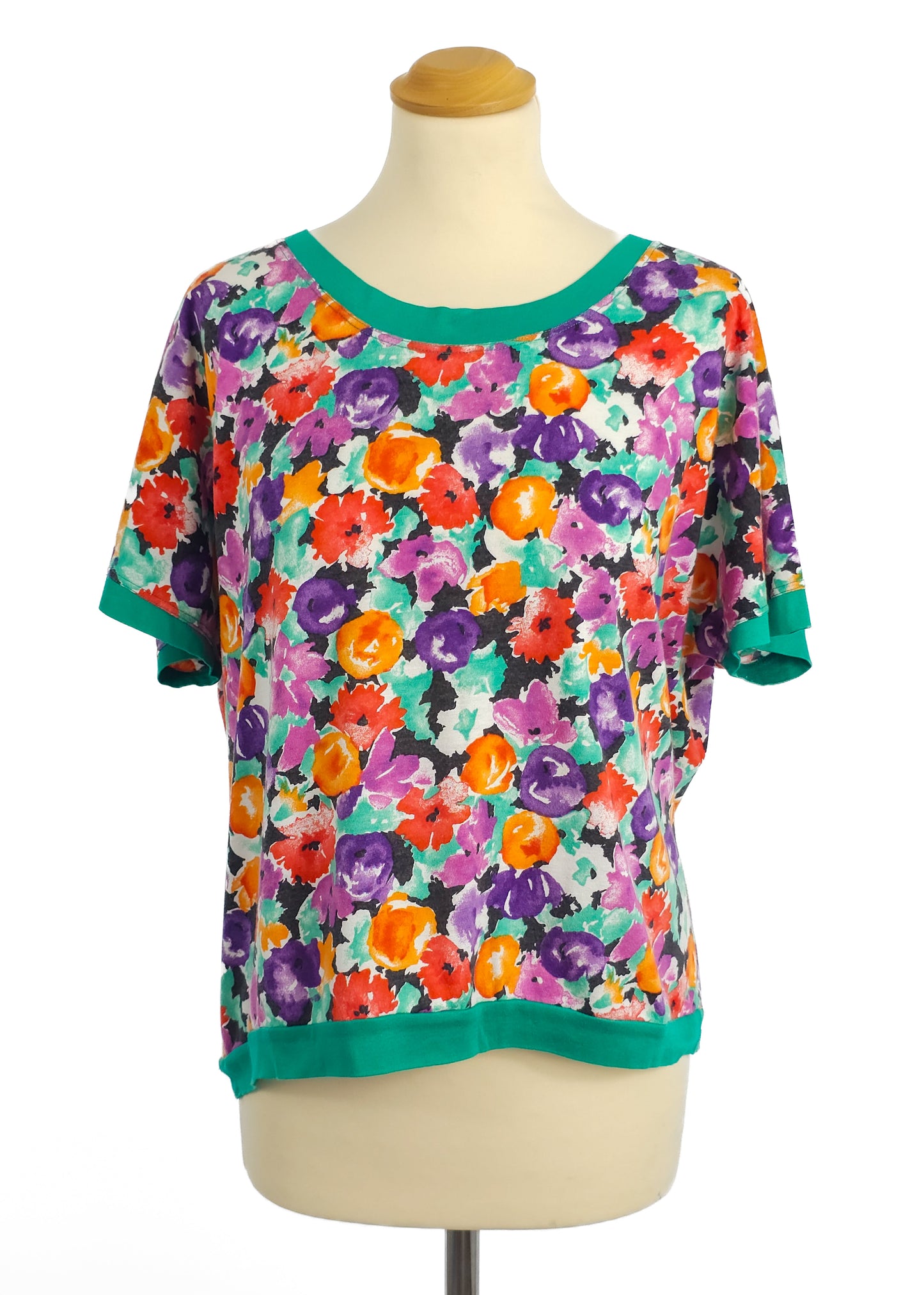Colorful floral T-shirt with green trim on a mannequin.