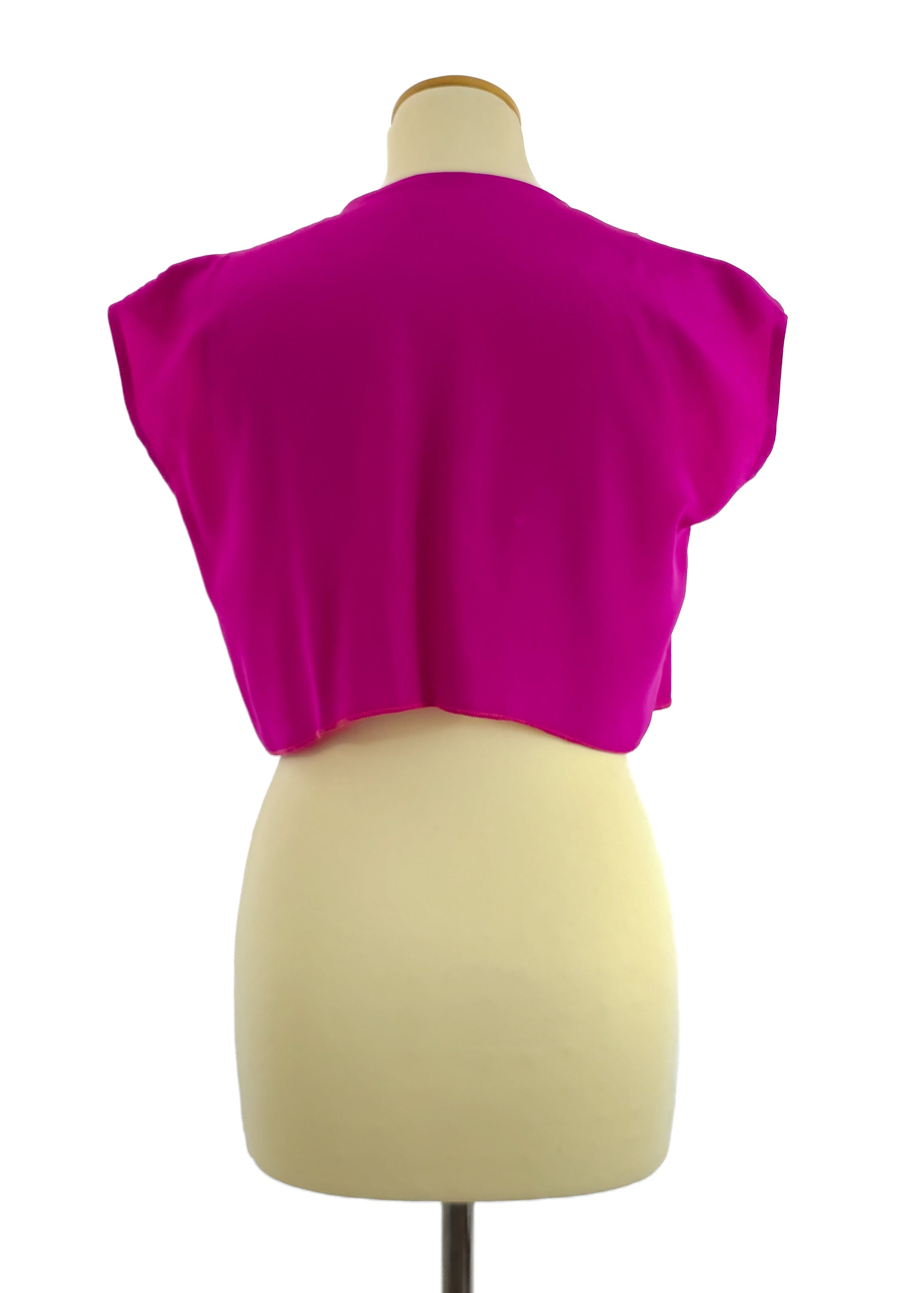 A mannequin displaying a bright pink vintage crop top with short sleeves. The top is viewed from the back, showcasing its simple and straight cut design.