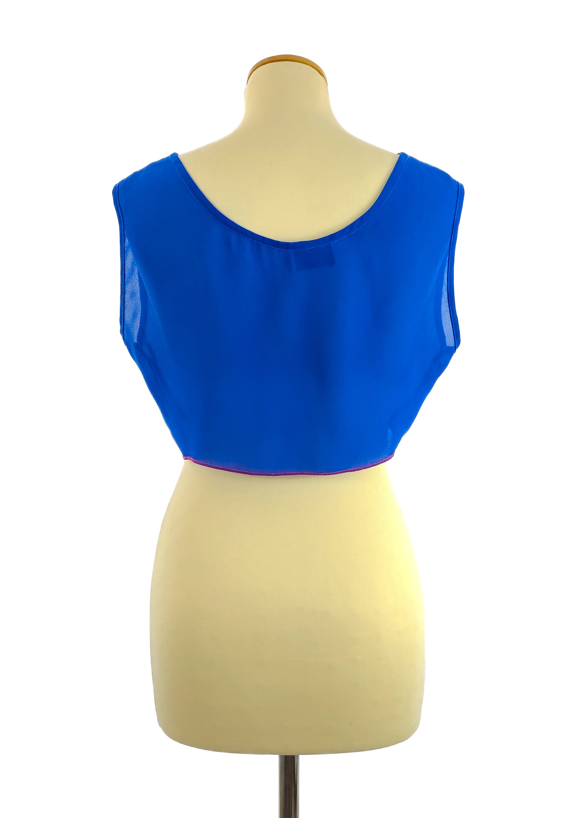 A mannequin wearing a sleeveless, bright blue crop top with a round neckline and a slightly sheer texture, viewed from the back.