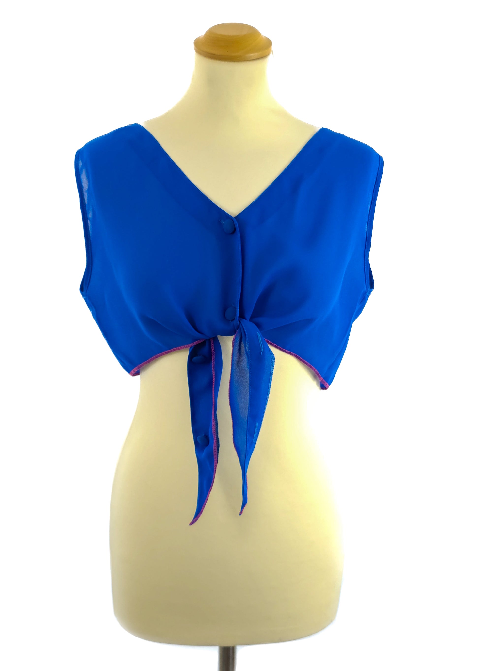 Blue sleeveless tie-front top on a mannequin with button details.