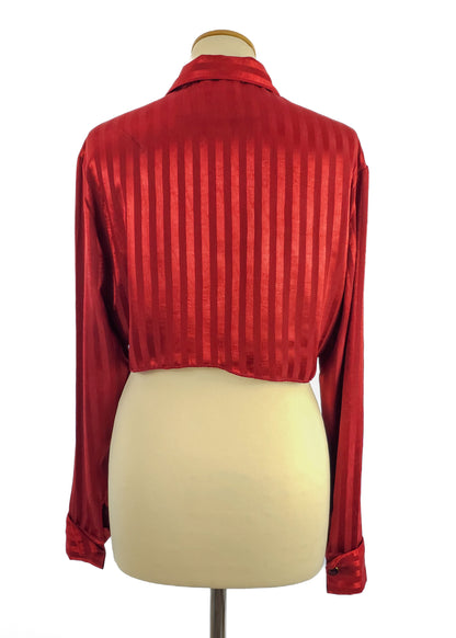 Red satin cropped blouse with vertical stripes, long sleeves, and buttoned cuffs displayed on a mannequin from the back.