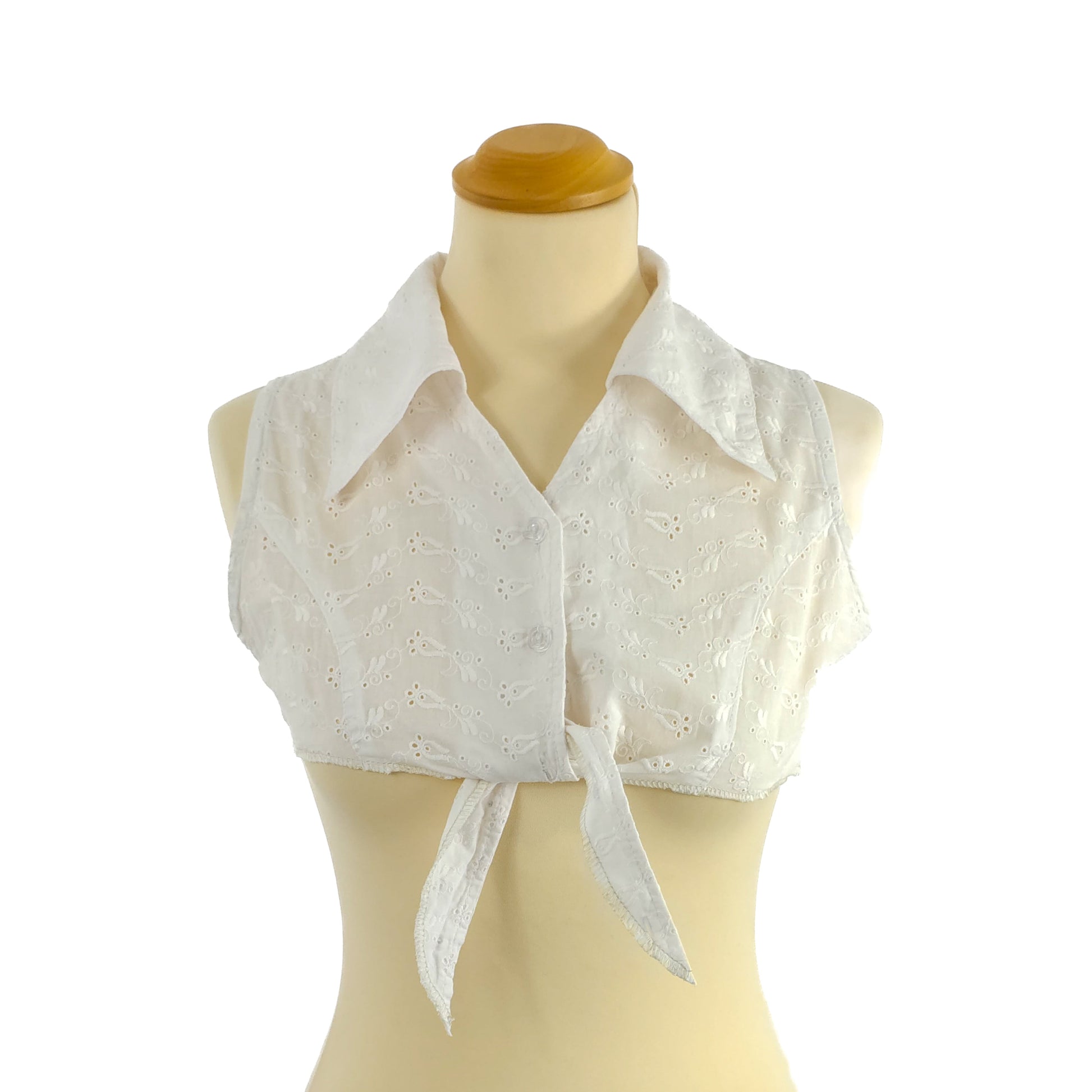 White sleeveless eyelet tie-front top on a mannequin.