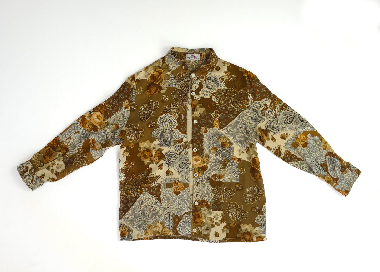 A vintage-style patchwork floral shirt with earthy tones and button-down front.