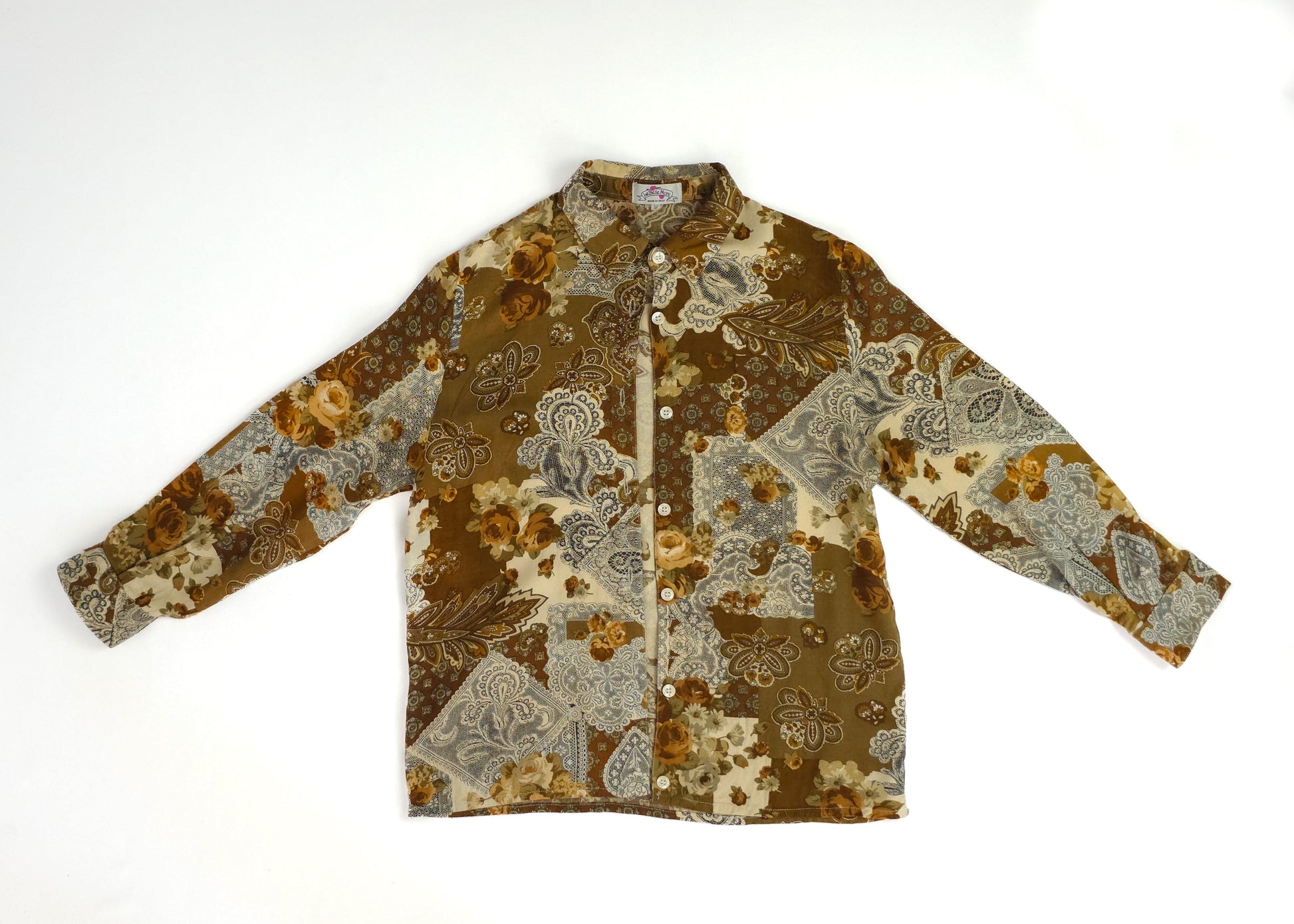 A vintage-style patchwork floral shirt with earthy tones and button-down front.